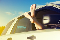 Woman Legs Out Car Window. Freedom Or Traveling Concept