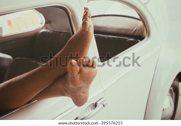 Woman legs out the\
windows in vintage car 