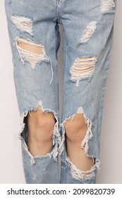 Woman Legs In Ripped Jeans Isolated On White Background