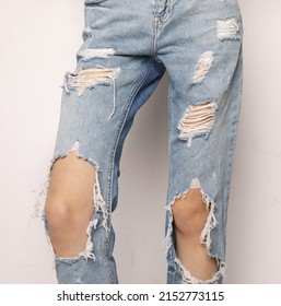 Woman Legs In Ripped Jeans Isolated On White Background