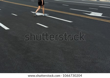 Woman legs in running movement, Close up picture of feet of young woman relax walking on the road, Healthy lifestyle concept. asian athlete walking on road in sunlight.