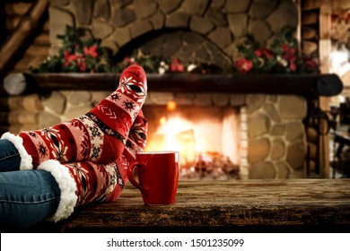 Woman Legs With Socks And Christmas Fireplace 