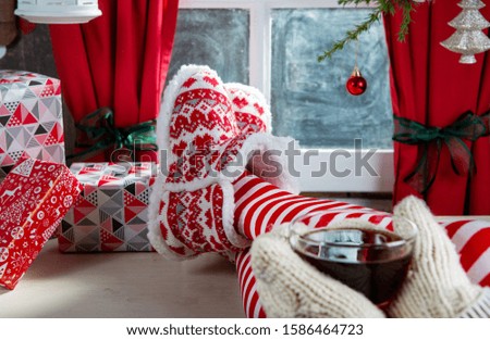 Woman legs with socks and slipper drinking tea, the Christmas concept