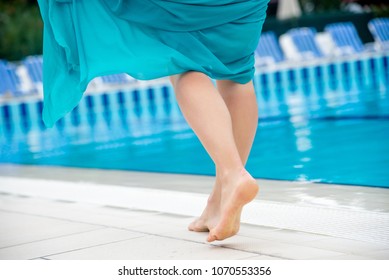 Woman Legs In A Swimming Pool.