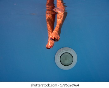 Woman Legs In The Swimming Pool