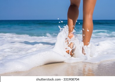 woman legs, walking on the beach