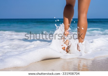 woman legs, walking on the beach