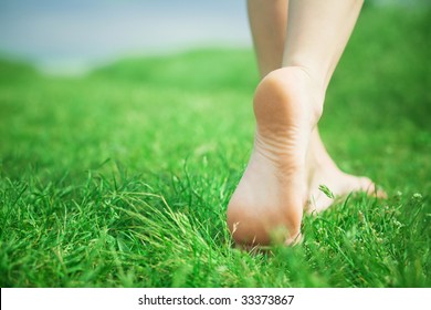 Mulher pernas andando na grama verde