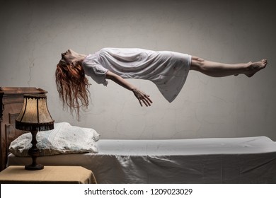 Woman levitating over bed / astral traveling, nightmare, excorcist halloween concept - Shutterstock ID 1209023029