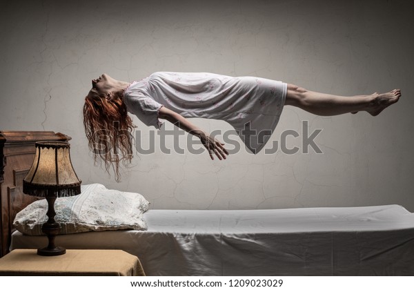 Woman levitating over bed / astral\
traveling, nightmare, excorcist halloween\
concept