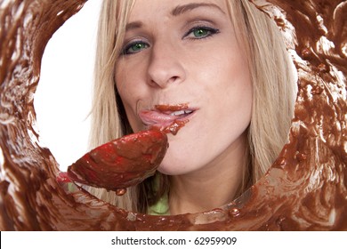 A Woman Is Licking The Batter From A Bowl.