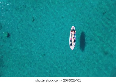 Woman Lie On Sup Board Doing Water Sport . Aerial Drone Top View