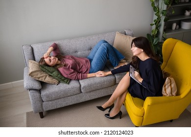 A Woman Lies On The Couch And Communicates With A Psychologist With A Woman In An Armchair. Methods Of Psychoanalysis