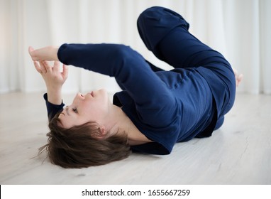 Woman lies on the floor and practices bodily practice in the gym.
