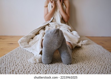 The Woman Lies In Warm Gray Socks In Bed And Covers Herself With A Blanket. Women's Legs In Cozy Socks. View From Above. Warm Evenings At Home
