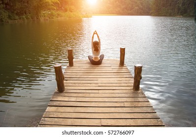 Woman Lifestyle Do Focused Yoga And Peaceful Outdoor. Person Exercising Zen Yoga At The Nature Background.  Healthy Concept