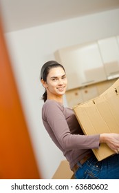 Woman Lifting Cardboard Box While Moving Home, Smiling.?