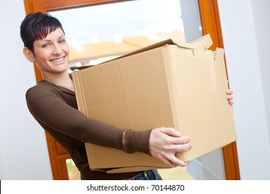 Woman Lifting Cardboard Box While Moving Home, Smiling.?