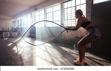 Woman Lifting Heavy Weights At The Gym For Muscle Training. Athlete Exercising Using A Weight Bar.