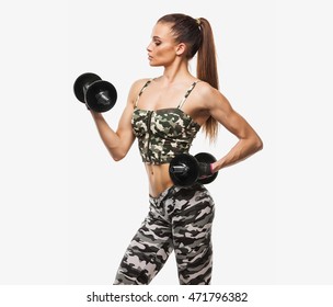 A woman is lifting some weights and wearing shorts