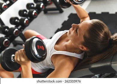 Woman Lifting Weights And Working On Her Chest At The Gym