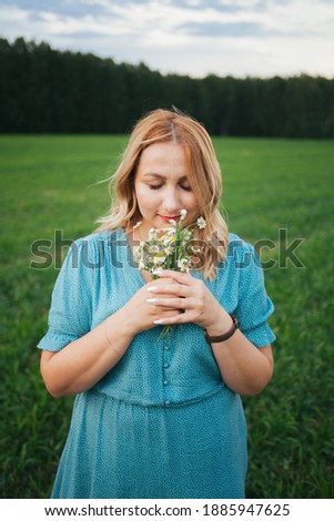 A woman in a light blue dress. A woman with a bouquet of wild flowers. A woman in nature.Natural beauty.unity with nature.Video portrait of a beautiful girl.