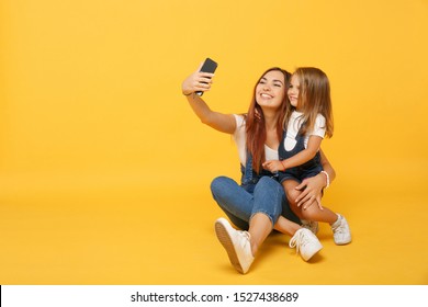 Woman in light clothes doing selfie with cute child baby girl 4-5 years old. Mommy little kid daughter isolated on yellow background studio portrait. Mother's Day family parenthood childhood concept - Powered by Shutterstock