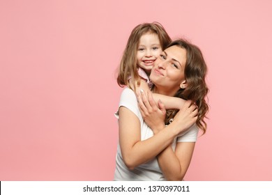 Woman in light clothes have fun with cute child baby girl. Mother, little kid daughter isolated on pastel pink wall background, studio portrait. Mother's Day love family, parenthood childhood concept