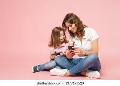 Woman in light clothes have fun with cute child baby girl. Mother, little kid daughter isolated on pastel pink wall background, studio portrait. Mother's Day love family, parenthood childhood concept - Powered by Shutterstock