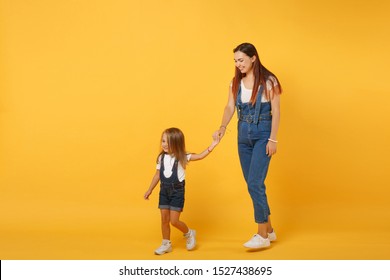 Woman In Light Clothes Have Fun With Cute Child Baby Girl 4-5 Years Old. Mommy Little Kid Daughter Isolated On Yellow Background Studio Portrait. Mother's Day Love Family Parenthood Childhood Concept