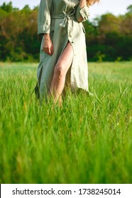 Woman In Linen Dress Walks In Tall Green Grass.