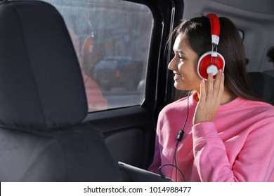 Woman Listening To Audiobook Through Headphones In Car