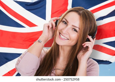 Woman Listening Language Learning Course Audiobook In Front Of British Flag