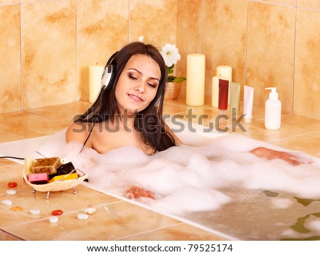 Woman listening to music in bubble  bath.