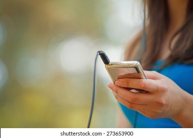 Woman listening music with headphones from ipod