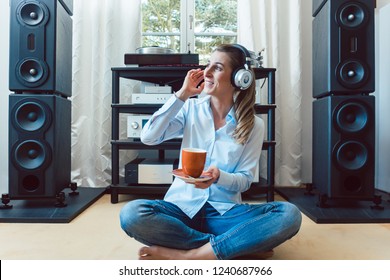 Woman listening to music from a Hi-Fi stereo at home