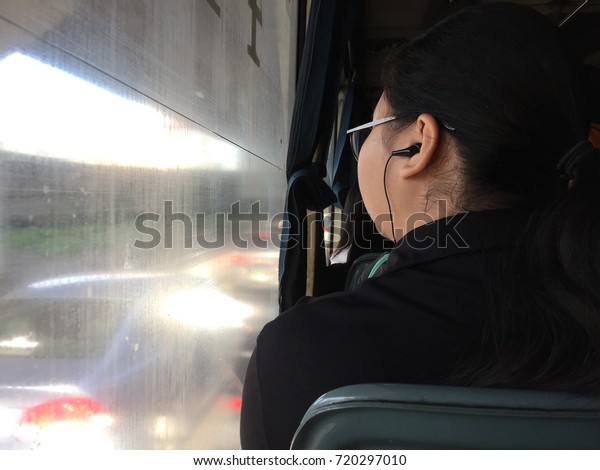 Woman\
listening to music on the bus while the traffic\
jam