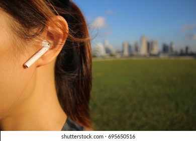 Woman Listening To Music Using Air Pods In The Outdoors