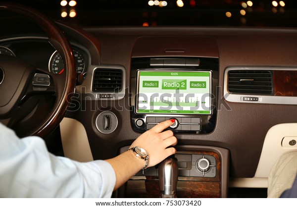 Woman\
listening to radio while driving car at\
night