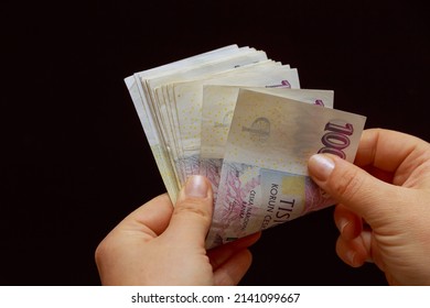 Woman lists Czech crowns on a black background. The national currency of the Czech Republic. Banknotes of one thousand krowns each. - Shutterstock ID 2141099667