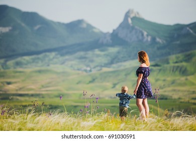 A woman with a little boy in the background of the mountains - Shutterstock ID 691030591