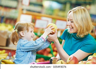 woman and little girl choosing apple during shopping at fruit vegetable supermarket