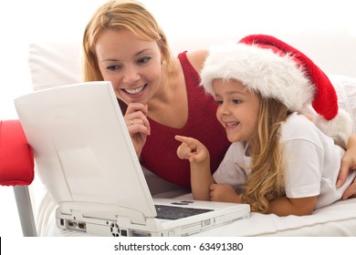 Woman And Little Girl Playing On A Laptop At Christmas Time - Online Shopping For Holidays Concept