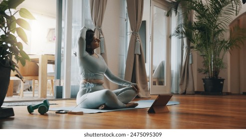 Woman, living room and stretching with tablet for yoga or online class, personal blog and content creation for internet. Girl, pose and calm in home for peace or mindset, exercise and mental health. - Powered by Shutterstock