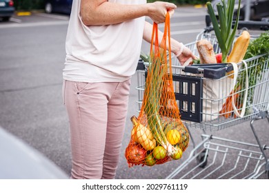 Woman Loading Groceries In Reusable Mesh Bags Into Car Trunk. Zero Waste And Plastic Free Shopping