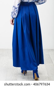 Woman In A Long Blue Skirt On White Background