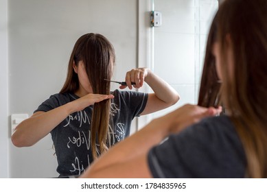 Woman With Long Brown Hair Cutting Her Own Bangs