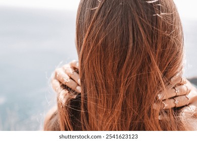 A woman with long brown hair is standing on a beach - Powered by Shutterstock