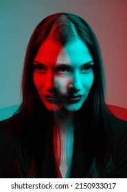 Woman With Long Dark Hair Close-up Fashion Portrait In RGB Color Split. RGB Effect Make Reflection Of Model Face In Red And Blue Colors. Abstract And Futuristic Looking Style