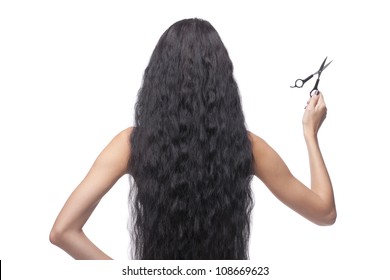 woman with long dark hair holding scissors